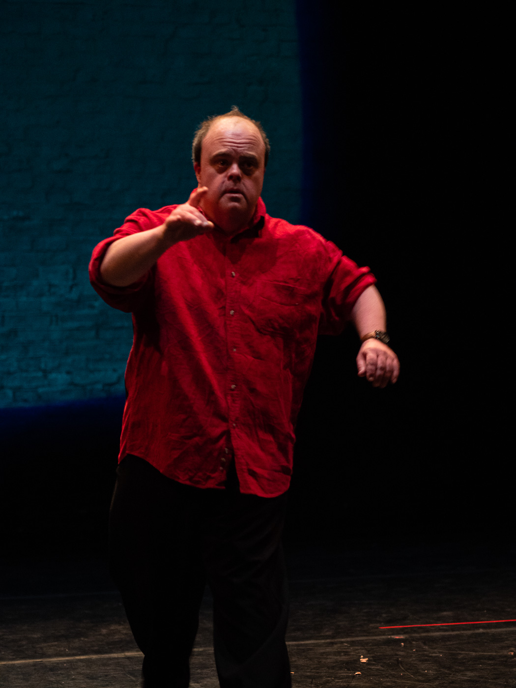 A photo of Graham with one hand lifted and his finger pointing